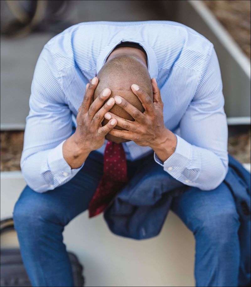 man covering his head with his two hands